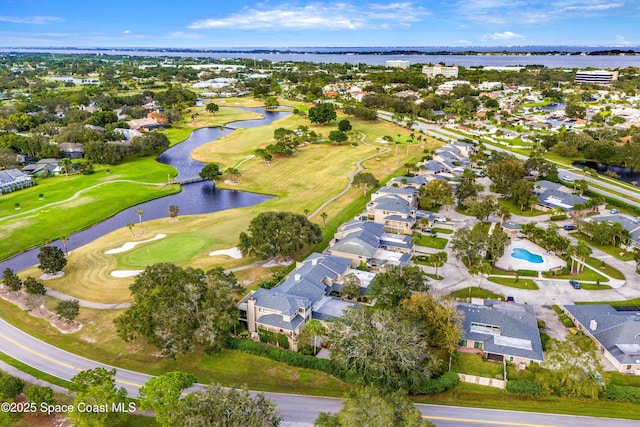 drone / aerial view with a residential view, golf course view, and a water view
