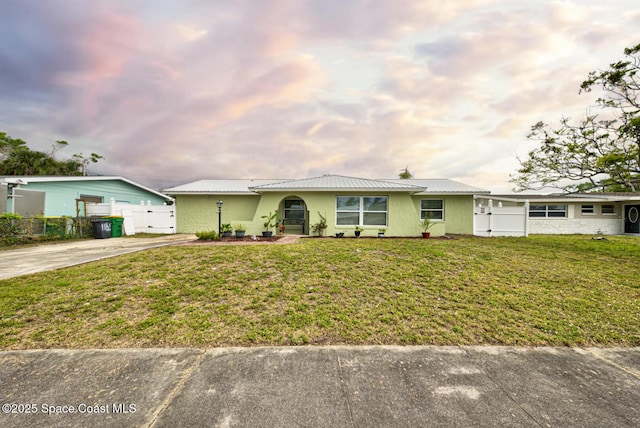 single story home with a gate, metal roof, a front yard, and fence