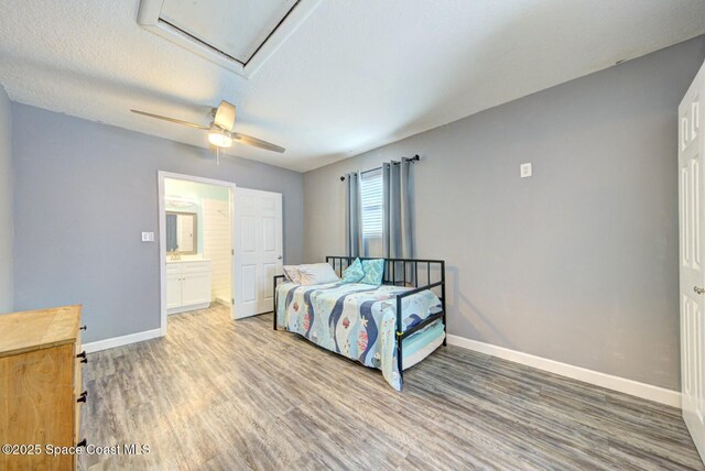 bedroom featuring baseboards, a textured ceiling, wood finished floors, and a ceiling fan