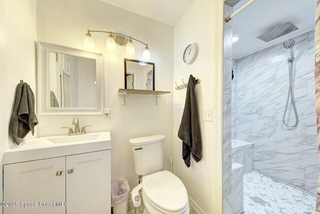 bathroom featuring toilet, vanity, and a tile shower
