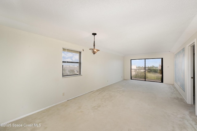 empty room with light carpet and a textured ceiling