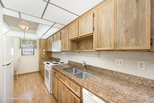 kitchen with tasteful backsplash, light stone countertops, light wood-style flooring, white appliances, and a sink