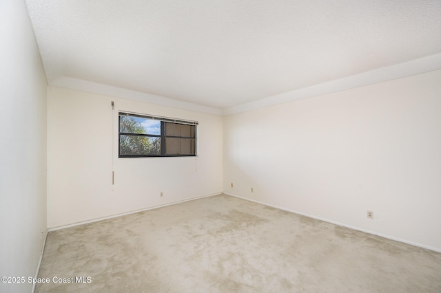 empty room featuring light colored carpet and a textured ceiling