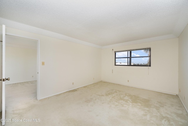 spare room with light carpet and a textured ceiling