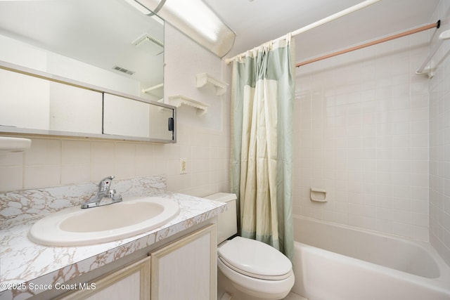 bathroom featuring vanity, visible vents, tile walls, toilet, and shower / tub combo with curtain