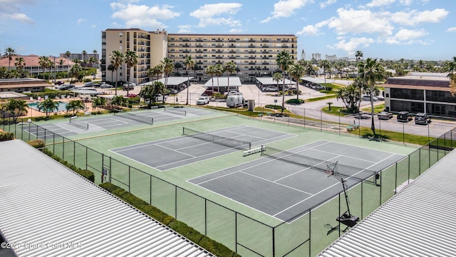 view of sport court featuring a view of city and fence