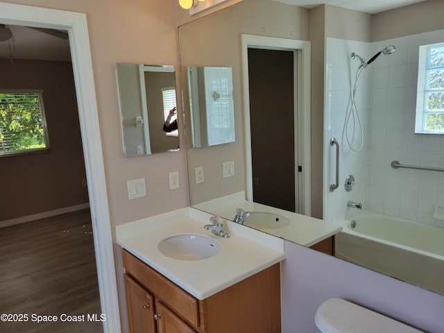 full bathroom featuring vanity, wood finished floors, baseboards, bathtub / shower combination, and toilet