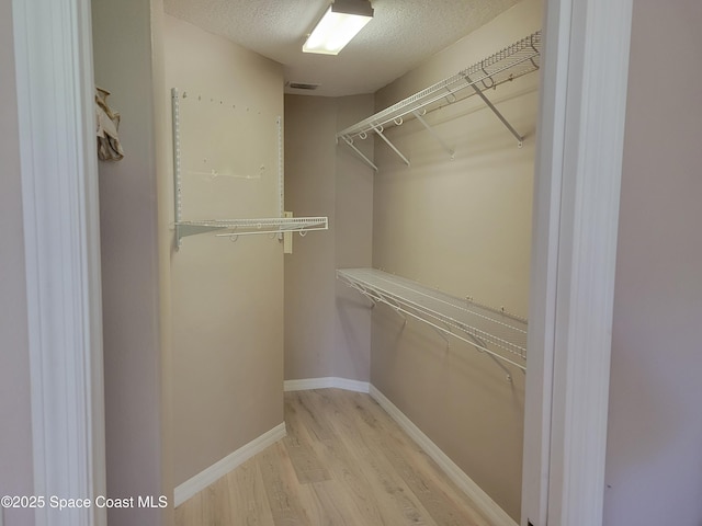 walk in closet with visible vents and light wood finished floors
