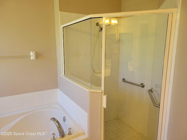 full bathroom with a shower stall and a bath