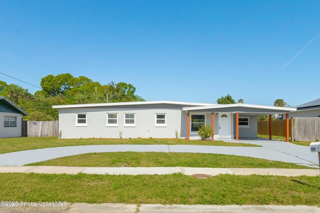 single story home featuring a front lawn, driveway, an attached carport, and fence