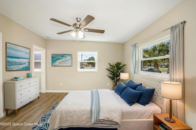 bedroom featuring baseboards, light wood-type flooring, and a ceiling fan