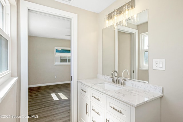 bathroom featuring baseboards, wood finished floors, and vanity
