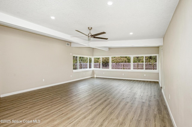 unfurnished room featuring baseboards, a textured ceiling, ceiling fan, and wood finished floors