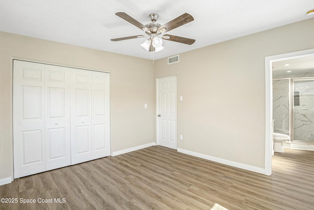 unfurnished bedroom featuring baseboards, a closet, and wood finished floors
