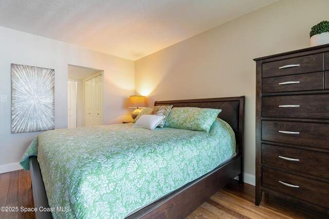 bedroom featuring wood finished floors and baseboards