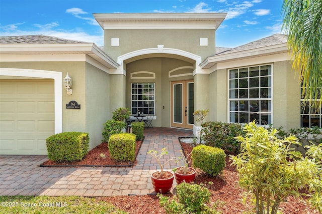 366 Gardendale Cir SE, Palm Bay, FL 32909 - property entrance featuring french doors, a garage, stucco siding, and roof with shingles