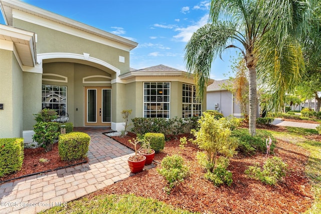 366 Gardendale Cir SE, Palm Bay, FL 32909 - view of exterior entry with stucco siding and french doors