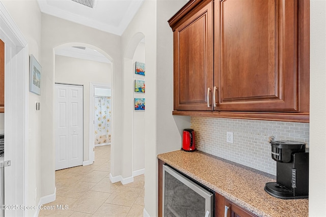 366 Gardendale Cir SE, Palm Bay, FL 32909 - kitchen with wine cooler, backsplash, light stone countertops, light tile patterned floors, and arched walkways