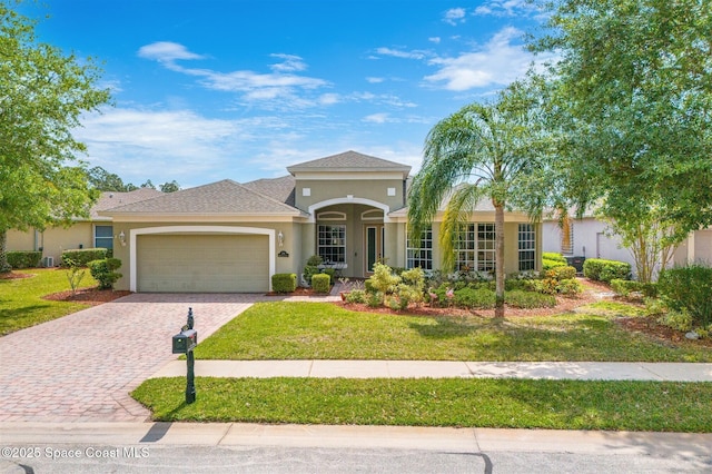366 Gardendale Cir SE, Palm Bay, FL 32909 - mediterranean / spanish-style home with a front lawn, driveway, stucco siding, and an attached garage