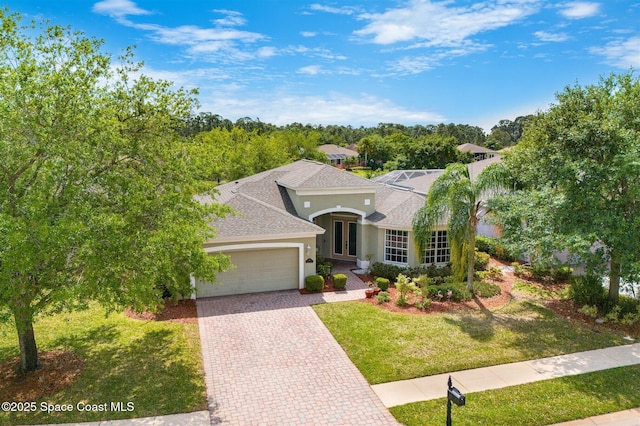 366 Gardendale Cir SE, Palm Bay, FL 32909 - mediterranean / spanish house with stucco siding, roof with shingles, an attached garage, french doors, and a front yard