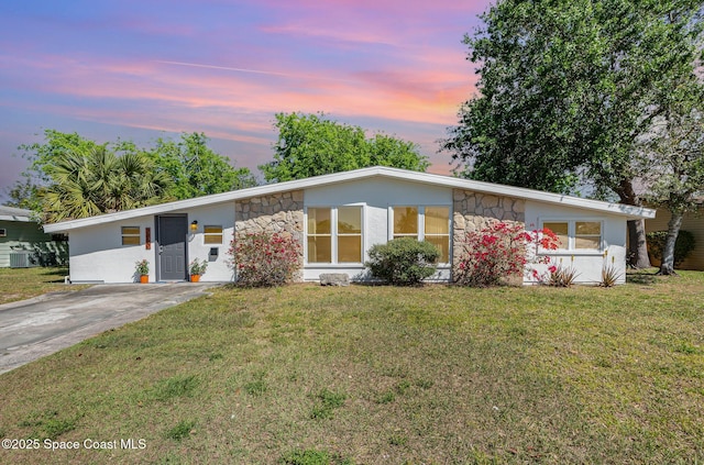 2880 Fountainhead Blvd, Melbourne, FL 32935 - mid-century home with stone siding, a yard, stucco siding, and central AC