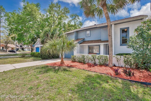 view of front facade with stucco siding, an attached garage, concrete driveway, and a front lawn