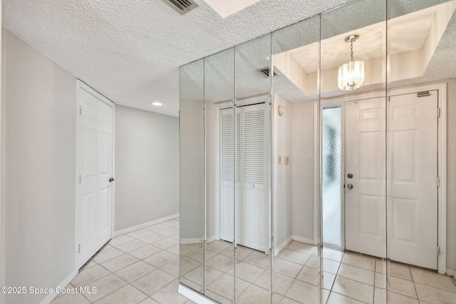 540 S Brevard Ave Unit 427, Cocoa Beach, FL 32931 - foyer featuring a chandelier, light tile patterned floors, and a textured ceiling