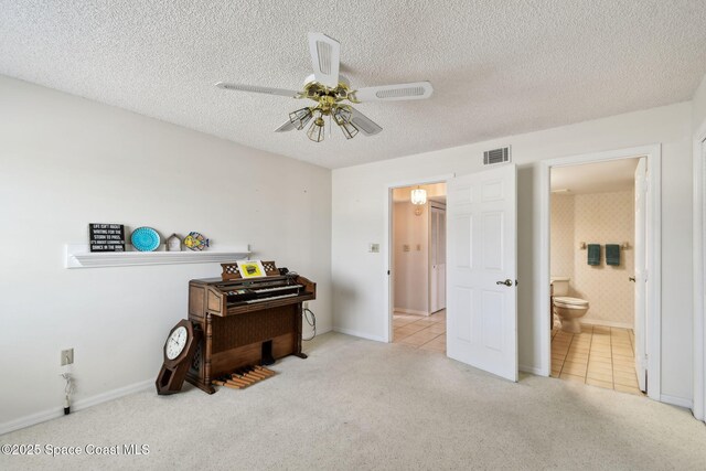 540 S Brevard Ave Unit 427, Cocoa Beach, FL 32931 - bedroom featuring carpet, tile patterned flooring, connected bathroom, a textured ceiling, and a ceiling fan