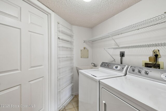 540 S Brevard Ave Unit 427, Cocoa Beach, FL 32931 - laundry area with independent washer and dryer, a textured ceiling, and light tile patterned flooring