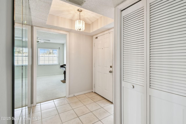 540 S Brevard Ave Unit 427, Cocoa Beach, FL 32931 - foyer entrance with a textured ceiling, a chandelier, light colored carpet, light tile patterned floors, and a raised ceiling