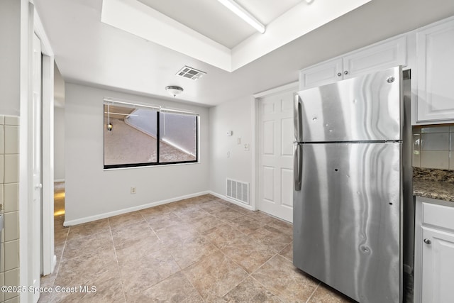 1730 Bluebird Ct, Melbourne, FL 32935 - kitchen with freestanding refrigerator, baseboards, white cabinetry, and visible vents