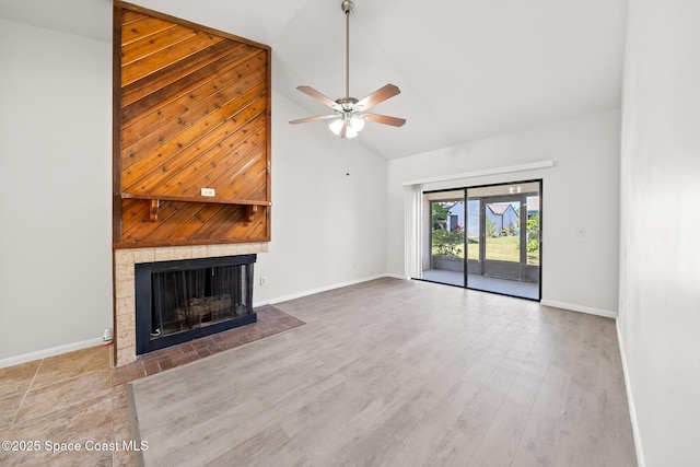 1730 Bluebird Ct, Melbourne, FL 32935 - unfurnished living room with baseboards, ceiling fan, high vaulted ceiling, a tile fireplace, and wood finished floors