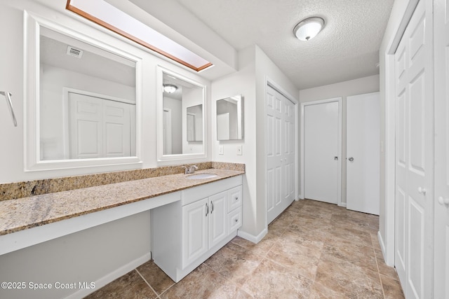 1730 Bluebird Ct, Melbourne, FL 32935 - bathroom with a textured ceiling, a closet, vanity, visible vents, and baseboards