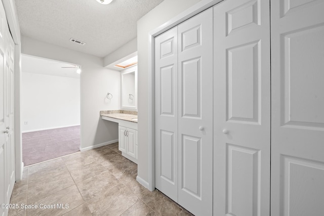 1730 Bluebird Ct, Melbourne, FL 32935 - bathroom featuring visible vents, baseboards, a closet, a textured ceiling, and vanity