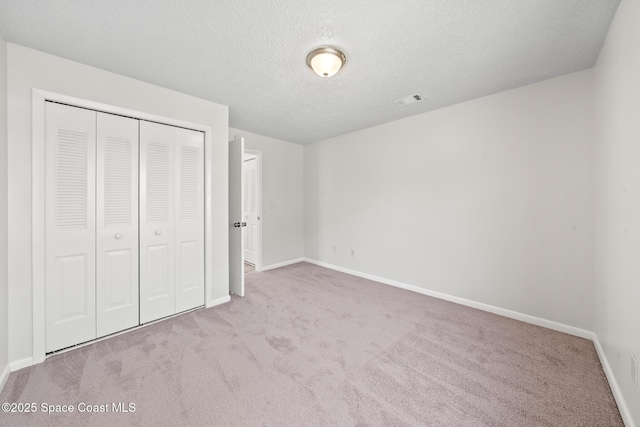 1730 Bluebird Ct, Melbourne, FL 32935 - unfurnished bedroom featuring a closet, baseboards, carpet flooring, a textured ceiling, and visible vents