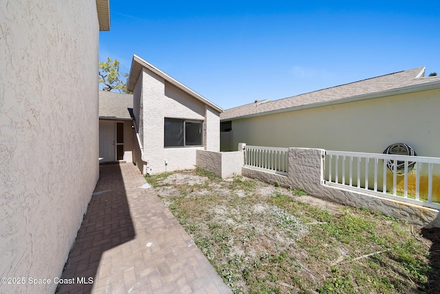 1730 Bluebird Ct, Melbourne, FL 32935 - property entrance with roof with shingles, stucco siding, and fence