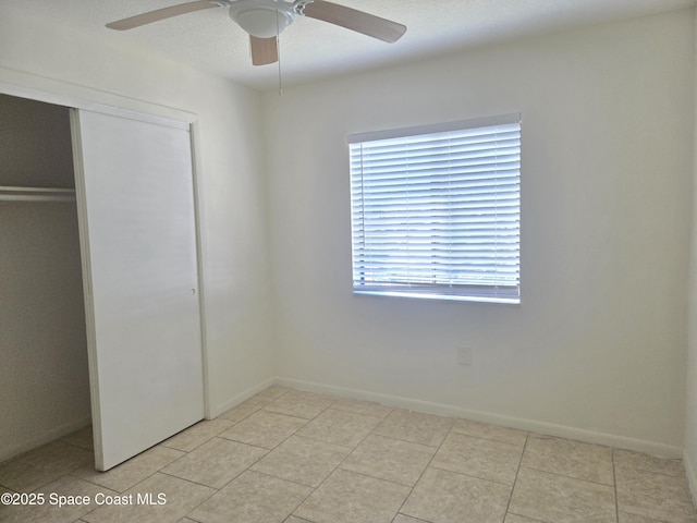 120 San Juan Cir, Melbourne, FL 32935 - unfurnished bedroom with ceiling fan, a closet, baseboards, and light tile patterned flooring
