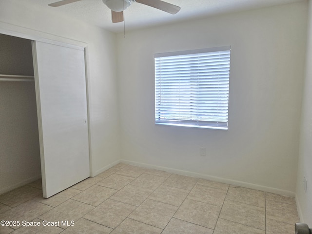 120 San Juan Cir, Melbourne, FL 32935 - unfurnished bedroom with light tile patterned floors, a closet, baseboards, and ceiling fan