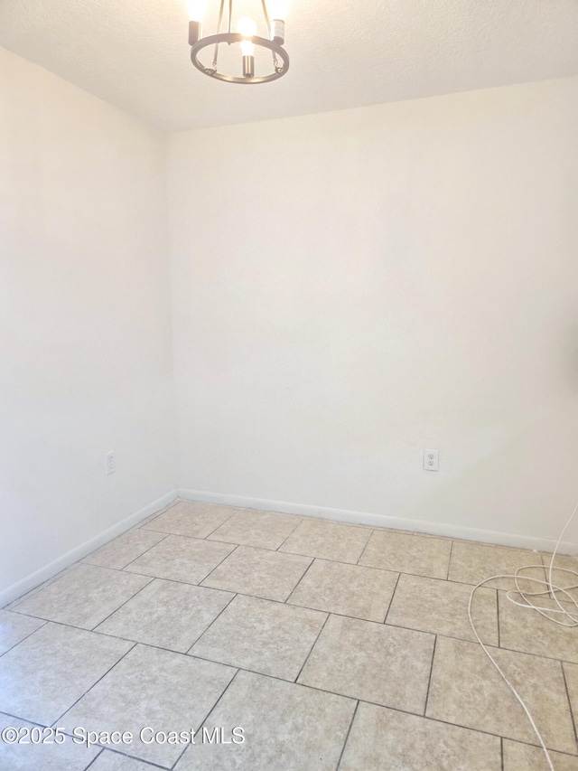 120 San Juan Cir, Melbourne, FL 32935 - spare room featuring a textured ceiling, light tile patterned floors, baseboards, and a chandelier
