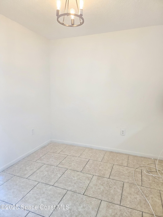 120 San Juan Cir, Melbourne, FL 32935 - empty room featuring baseboards, a notable chandelier, and light tile patterned flooring