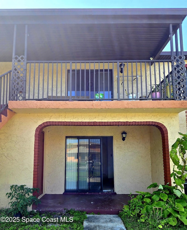 120 San Juan Cir, Melbourne, FL 32935 - rear view of property with stucco siding and a balcony