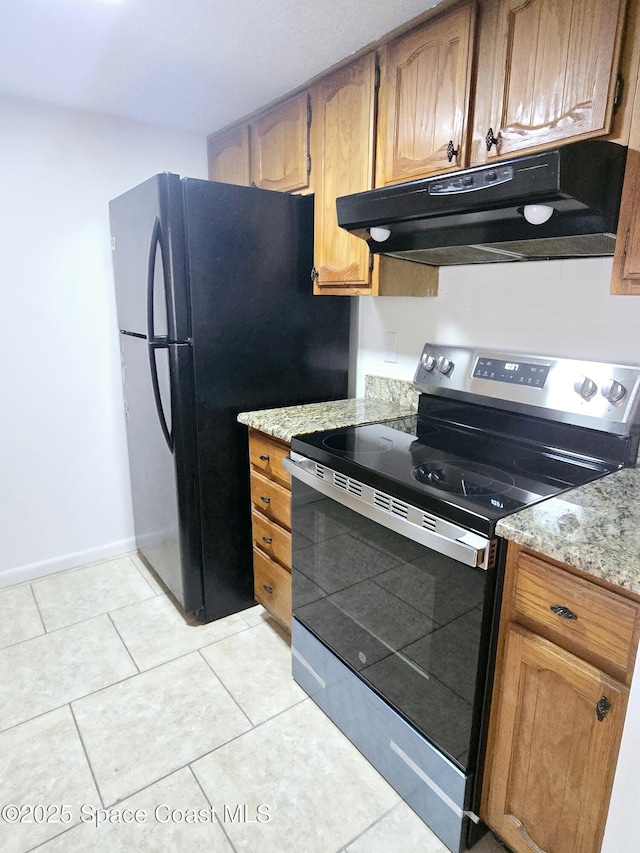120 San Juan Cir, Melbourne, FL 32935 - kitchen featuring stainless steel range with electric stovetop, under cabinet range hood, freestanding refrigerator, light tile patterned floors, and baseboards