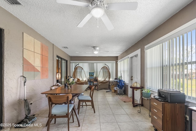 sunroom / solarium featuring plenty of natural light, visible vents, and a textured wall
