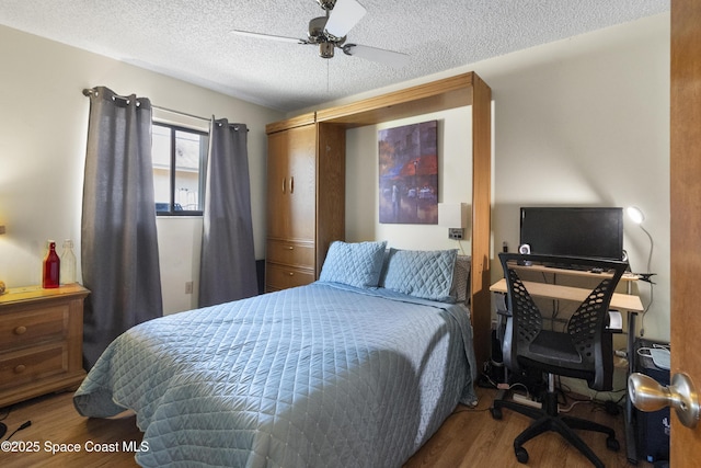 bedroom with a textured ceiling, wood finished floors, and a ceiling fan