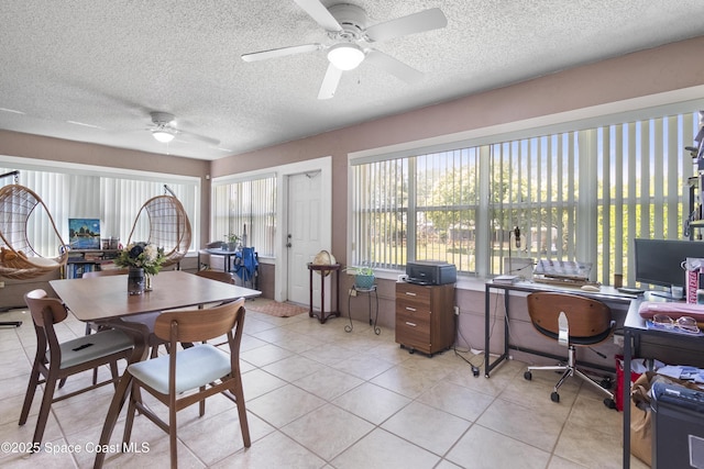 dining area featuring light tile patterned flooring, a healthy amount of sunlight, a textured ceiling, and a ceiling fan