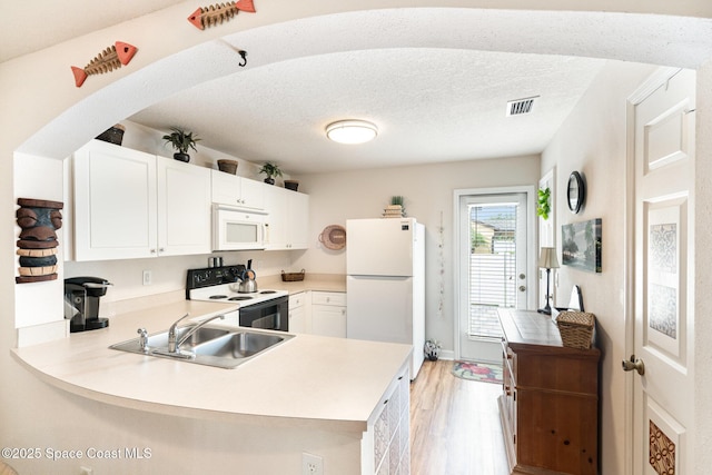 785 Luminary Cir Unit 103, Melbourne, FL 32901 - kitchen with white appliances, a sink, light wood finished floors, a peninsula, and light countertops