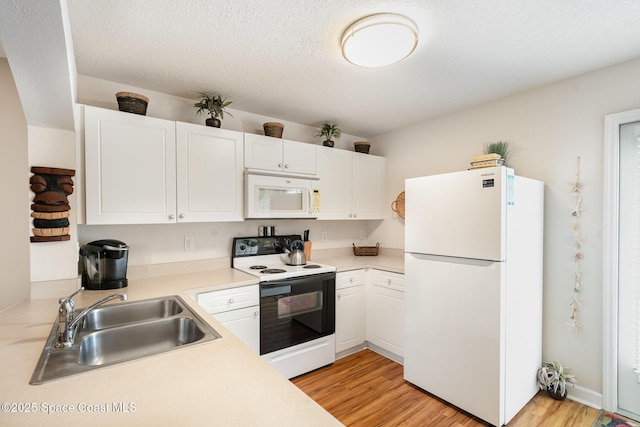 785 Luminary Cir Unit 103, Melbourne, FL 32901 - kitchen with white appliances, a sink, light wood-style flooring, light countertops, and white cabinetry