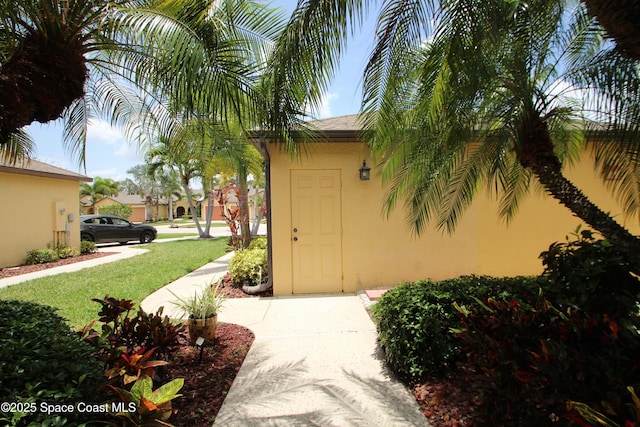 785 Luminary Cir Unit 103, Melbourne, FL 32901 - doorway to property with stucco siding and a lawn