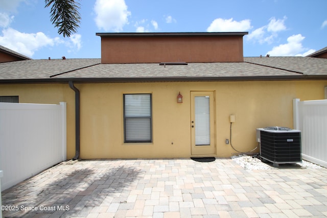 785 Luminary Cir Unit 103, Melbourne, FL 32901 - rear view of house with central AC unit, roof with shingles, a patio, and stucco siding