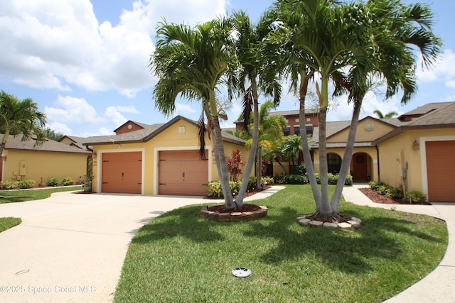 785 Luminary Cir Unit 103, Melbourne, FL 32901 - view of front of property featuring a front yard, an attached garage, driveway, and stucco siding